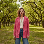 Woman in a pink coat standing in an orchard