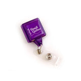 Purple badge holder with 'Handi Quilter' branding on a white background