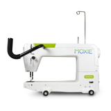 White sewing machine with black arm and green accents on a white background, branded 'Moxie'.