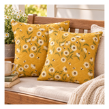 Two quilted decorative pillows made with Ladybug Whimsy Daisy fabric featuring white daisies and tiny bees on a golden yellow background.