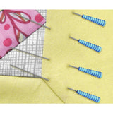 Needles and sewing tools on a yellow fabric background