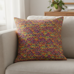 Colorful patterned pillow on a beige sofa with a neutral background