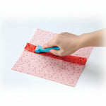 Roll and press being used on a piece of fabric