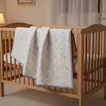 fabric as a baby quilt hanging over a crib