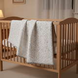 fabric as a baby quilt hanging over a crib
