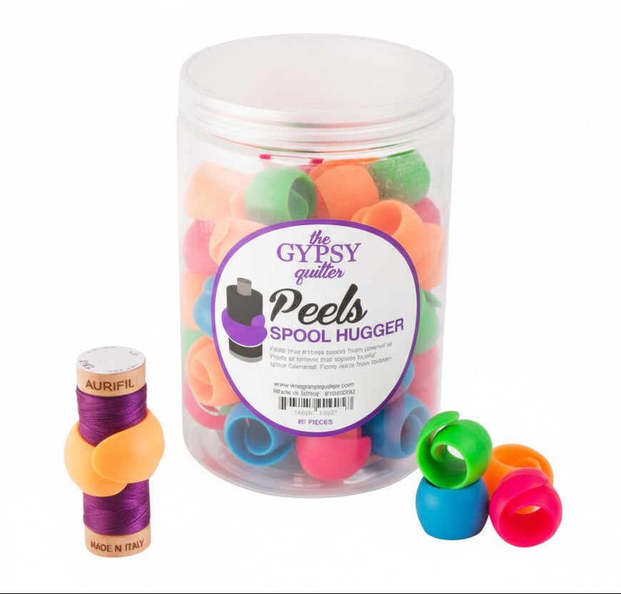 Colorful spool huggers with a container labeled 'The Gypsy Quilter' on a white background