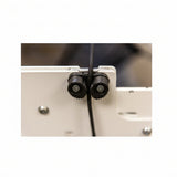 Close-up of a mechanical component with gears and a cable on a blurred background