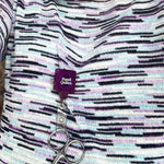 Scissors attached to a purple 'Handi Quilter' lanyard on a patterned fabric background
